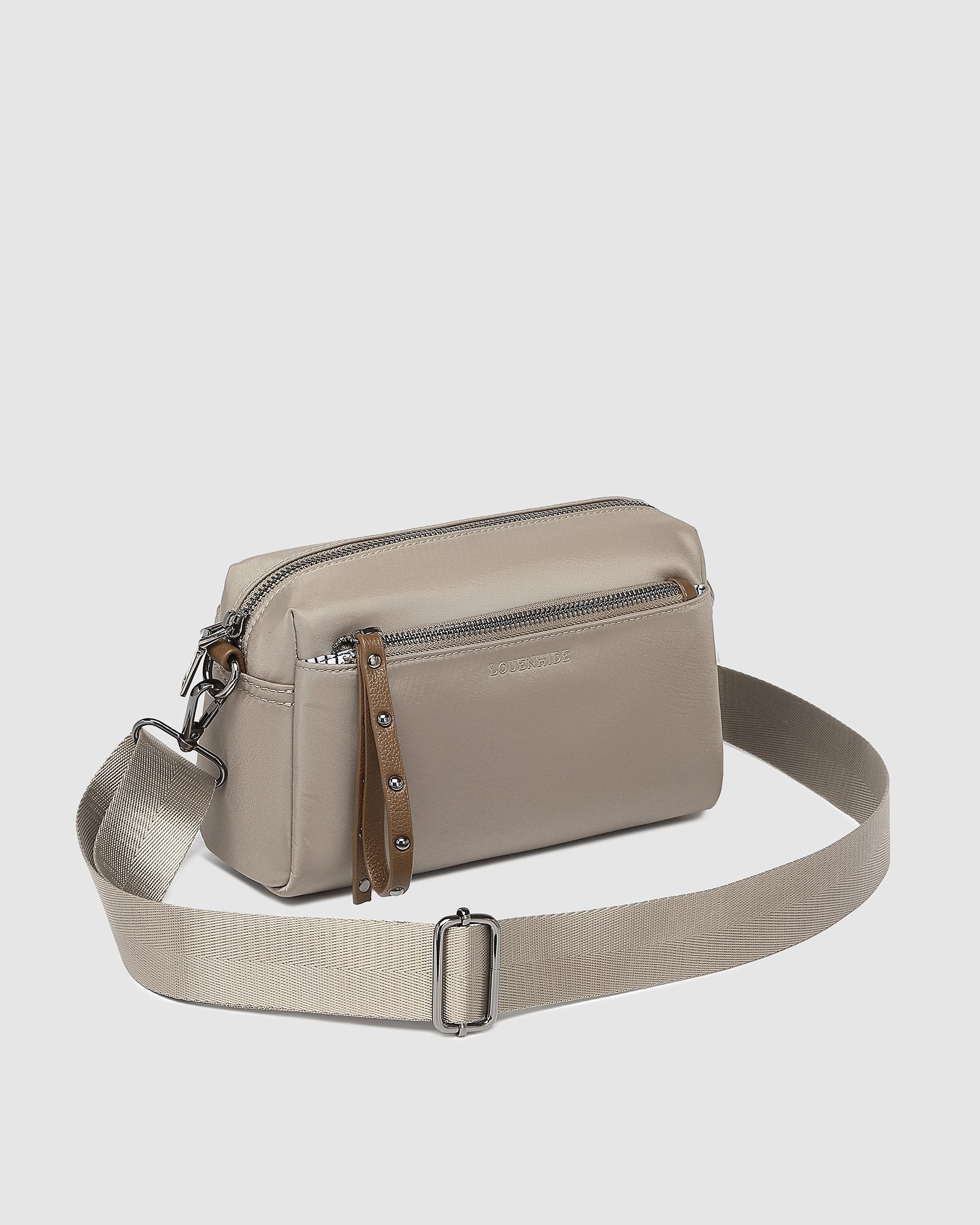 The Louenhide Rowie Nylon Crossbody Bag is the practical, everyday accessory you've been searching for. Embrace an organized dream with multiple internal and external pockets and a stylish matching cardholder. The Rowie's minimalist&nbsp;design is enhanced by the gunmetal detailing - adding the perfect touch of contemporary edge to its classic silhouette.&nbsp; Whether you're exploring the city or embarking on an adventure, this crossbody bag effortlessly complements your capsule wardrobe. 