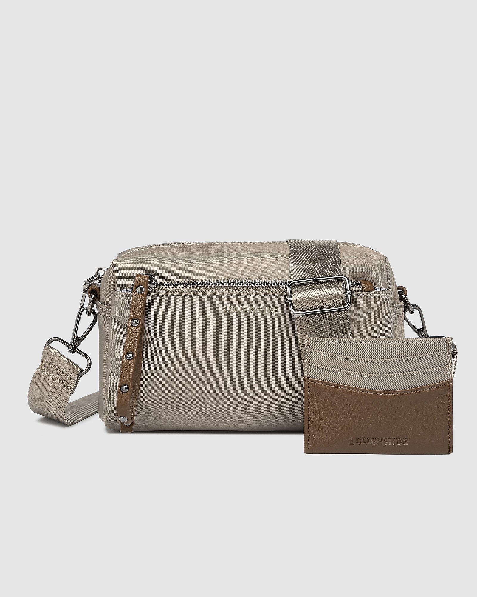 The Louenhide Rowie Nylon Crossbody Bag is the practical, everyday accessory you've been searching for. Embrace an organized dream with multiple internal and external pockets and a stylish matching cardholder. The Rowie's minimalist&nbsp;design is enhanced by the gunmetal detailing - adding the perfect touch of contemporary edge to its classic silhouette.&nbsp; Whether you're exploring the city or embarking on an adventure, this crossbody bag effortlessly complements your capsule wardrobe. 