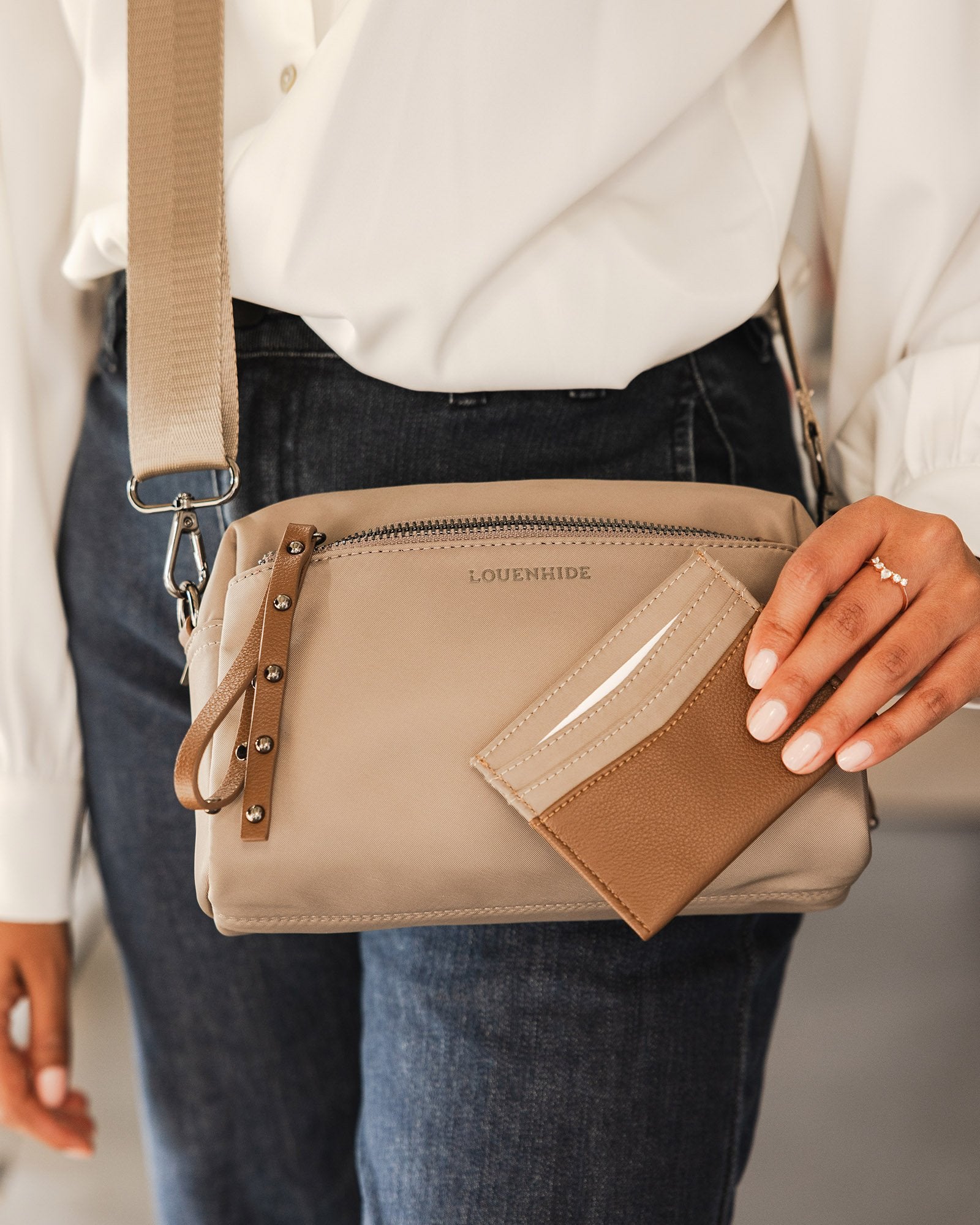 The Louenhide Rowie Nylon Crossbody Bag is the practical, everyday accessory you've been searching for. Embrace an organized dream with multiple internal and external pockets and a stylish matching cardholder. The Rowie's minimalist&nbsp;design is enhanced by the gunmetal detailing - adding the perfect touch of contemporary edge to its classic silhouette.&nbsp; Whether you're exploring the city or embarking on an adventure, this crossbody bag effortlessly complements your capsule wardrobe. 