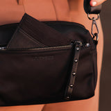 The Louenhide Rowie Nylon Crossbody Bag is the practical, everyday accessory you've been searching for. Embrace an organized dream with multiple internal and external pockets and a stylish matching cardholder. The Rowie's minimalist&nbsp;design is enhanced by the gunmetal detailing - adding the perfect touch of contemporary edge to its classic silhouette.&nbsp; Whether you're exploring the city or embarking on an adventure, this crossbody bag effortlessly complements your capsule wardrobe. 