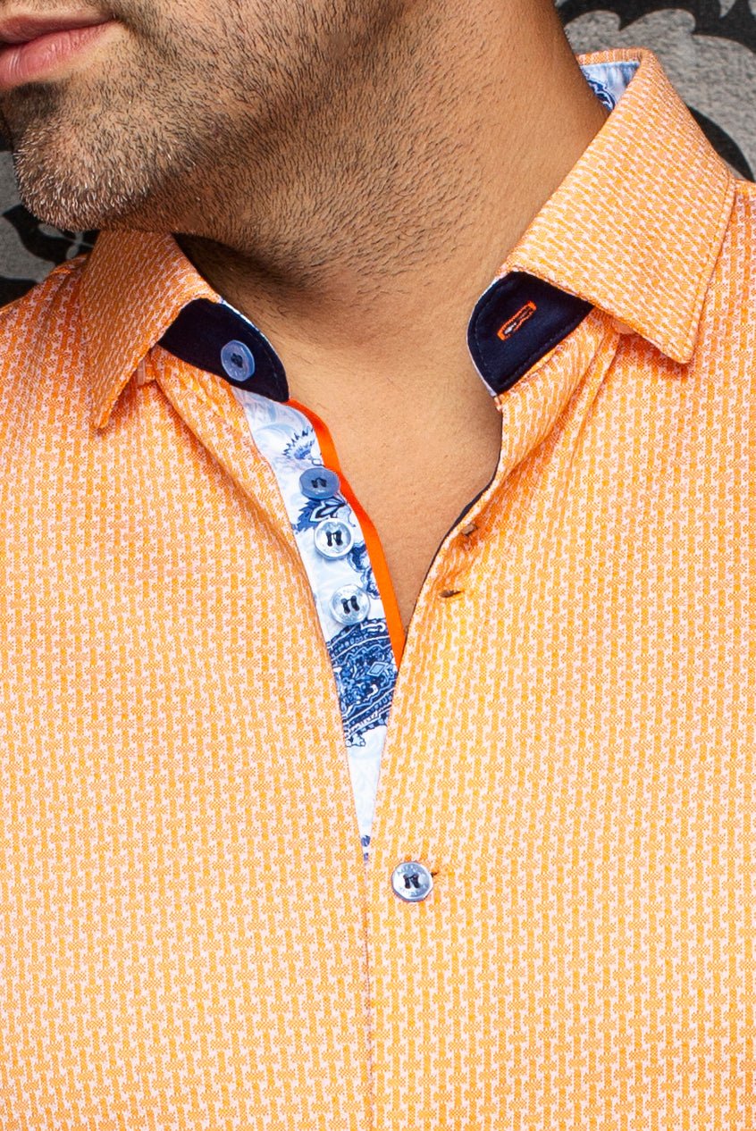Close-up of a person wearing an orange shirt with a patterned collar.