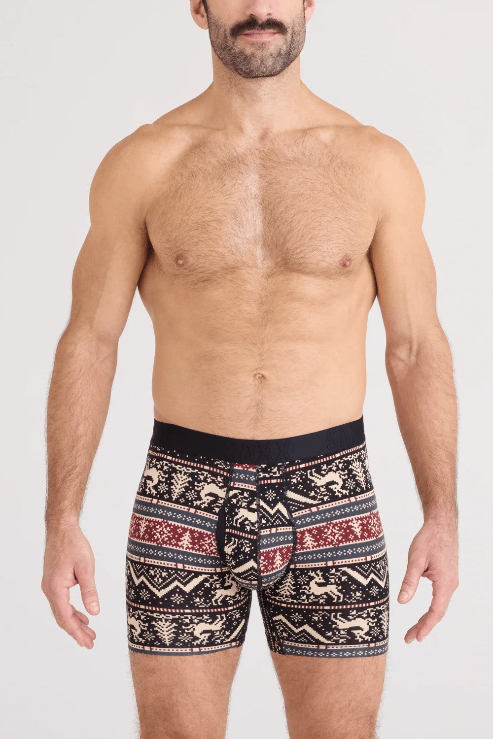 Man wearing patterned boxer briefs on a plain background