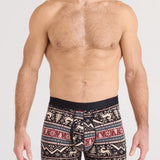 Man wearing patterned boxer briefs on a plain background