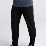 Person wearing black pants and gray shoes on a white background