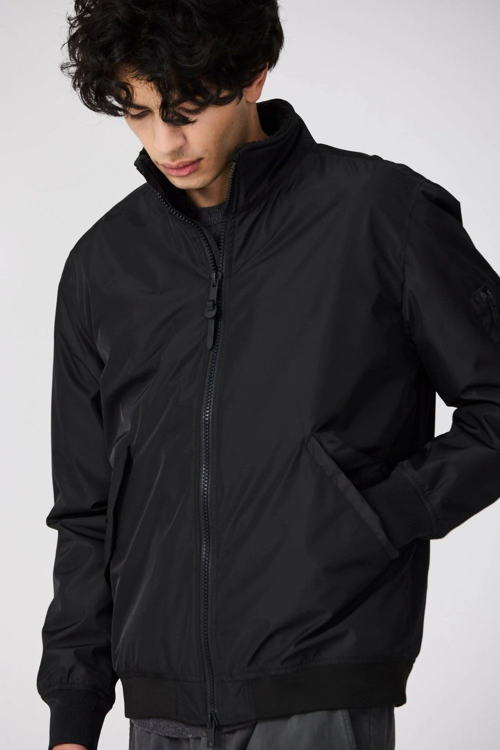 Person wearing a black jacket on a white background