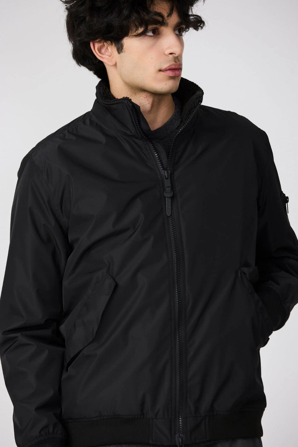 Man wearing a black jacket against a white background
