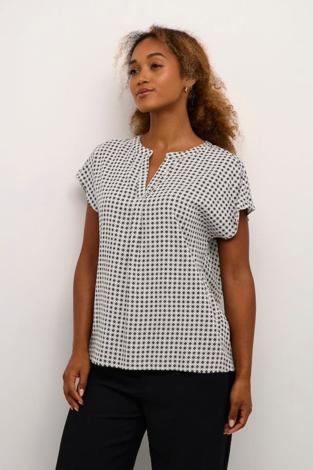 Experience comfort and style with this loose-fit, hip-length blouse. Perfect for daily wear, this short-sleeve, tiny graphic print woven blouse features flattering wing sleeves.