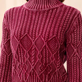 Close-up of a person wearing a maroon sweater with a geometric pattern on a beige background