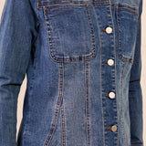 Blue denim jacket with buttons on a neutral background