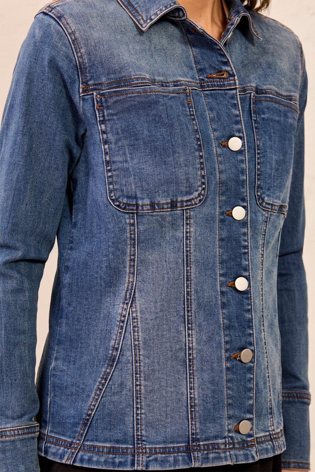 Blue denim jacket with buttons on a neutral background