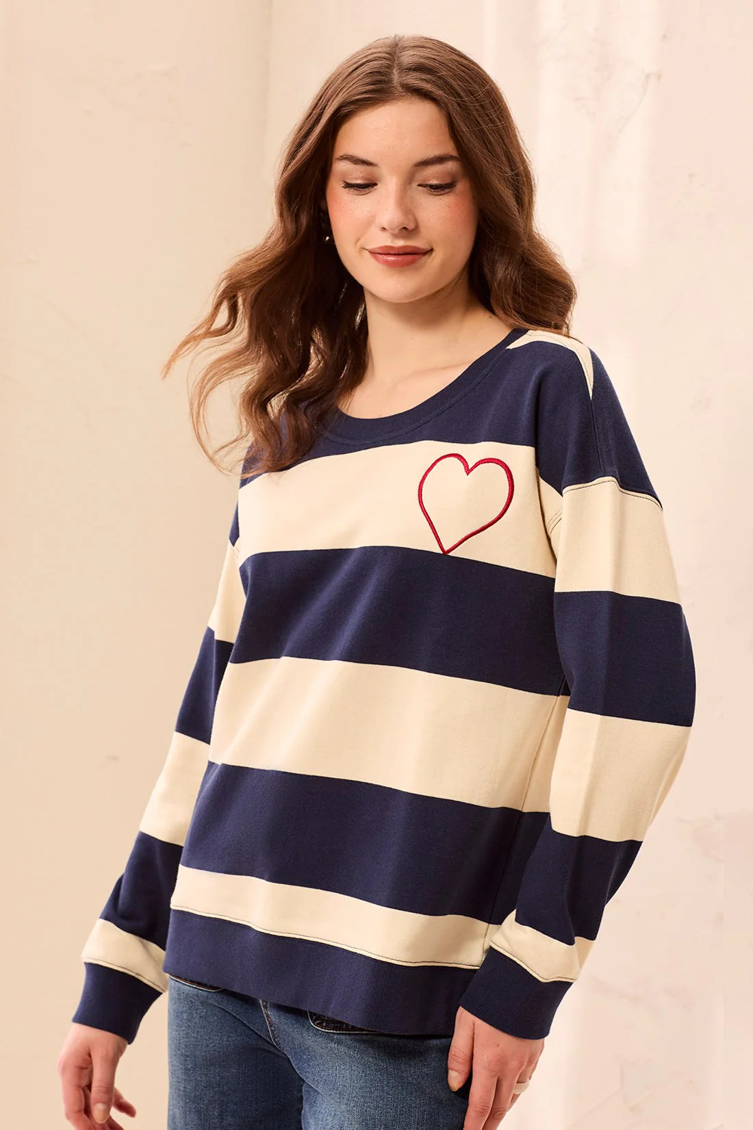 This charming long-sleeve knit pullover features a classic nautical stripe pattern accented by a vibrant embroidered red heart for a playful, romantic touch. Designed with a relaxed drop shoulder and a cozy crew neckline, it offers an effortless silhouette that perfectly balances casual comfort with elevated style.
