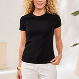Woman wearing a black t-shirt and white pants in a light interior setting