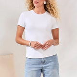 Woman wearing a white t-shirt and denim shorts against a plain background