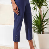 Woman wearing a white shirt with navy capris on a white background