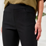 Woman wearing green top with black ankle pants on a white background