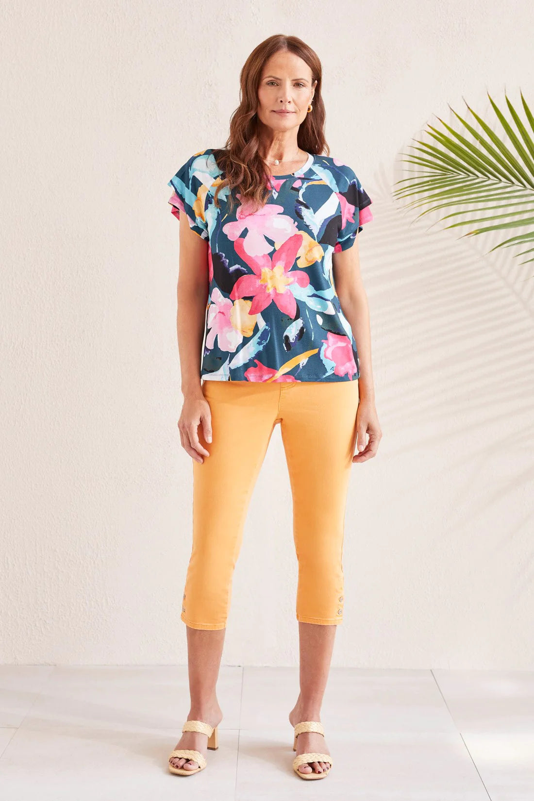 Bold florals define this crew neck top that sports a vibrant print and a 5/8'' neckband. Double ruffle short sleeves unfurl down from either shoulder while raglan armholes and printed rayon jersey fabric add a touch of easygoing flow and comfort.