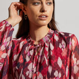 Instantly rejuvenate your everyday wardrobe with this printed blouse that promotes airy breathability with a flowy fit and Swiss dot chiffon fabric. 