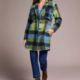 Woman wearing a plaid coat with a neutral background