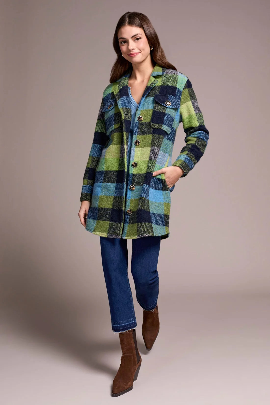Woman wearing a plaid coat with a neutral background