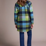 Person wearing a plaid coat with a neutral background