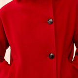 Red coat with black buttons on a neutral background