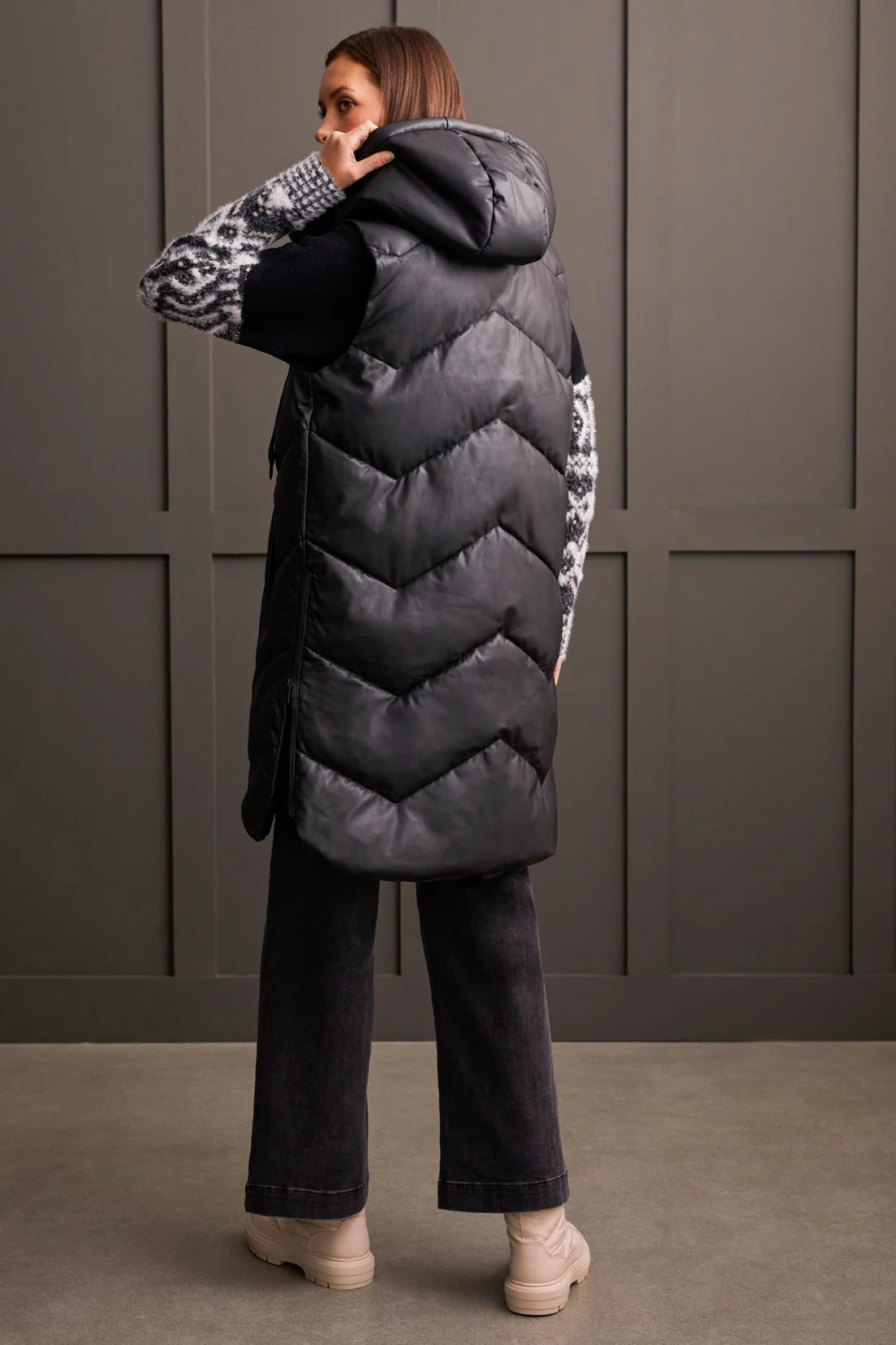 An off-season essential that serves up style points and practical performance. This zip-up puffer vest features a loose fit, chevron quilting, and a hooded neckline that surrounds you with cozy comfort, a 38" long design, front welt pockets, and zippered side seams that allow for more ventilation and moveability when required.