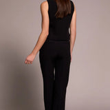 Woman wearing a black sleeveless top and black pants against a plain background