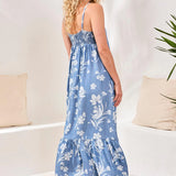 Woman wearing a blue floral dress in a minimal indoor setting