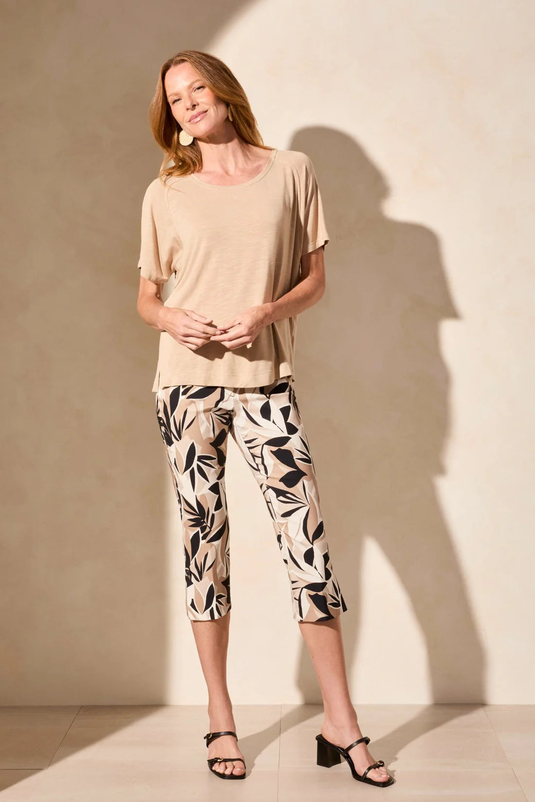 Infuse your style with vibrant personality in these pull-on capri pants, featuring bold printed bengaline fabric. The straight leg design is enhanced by adjustable side vents at the hem, elegantly finished with fabric-covered buttons. Practical front and back pockets complete the look, combining style with functionality.