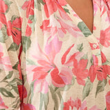 Close-up of a floral blouse with pink and green flowers on a beige background
