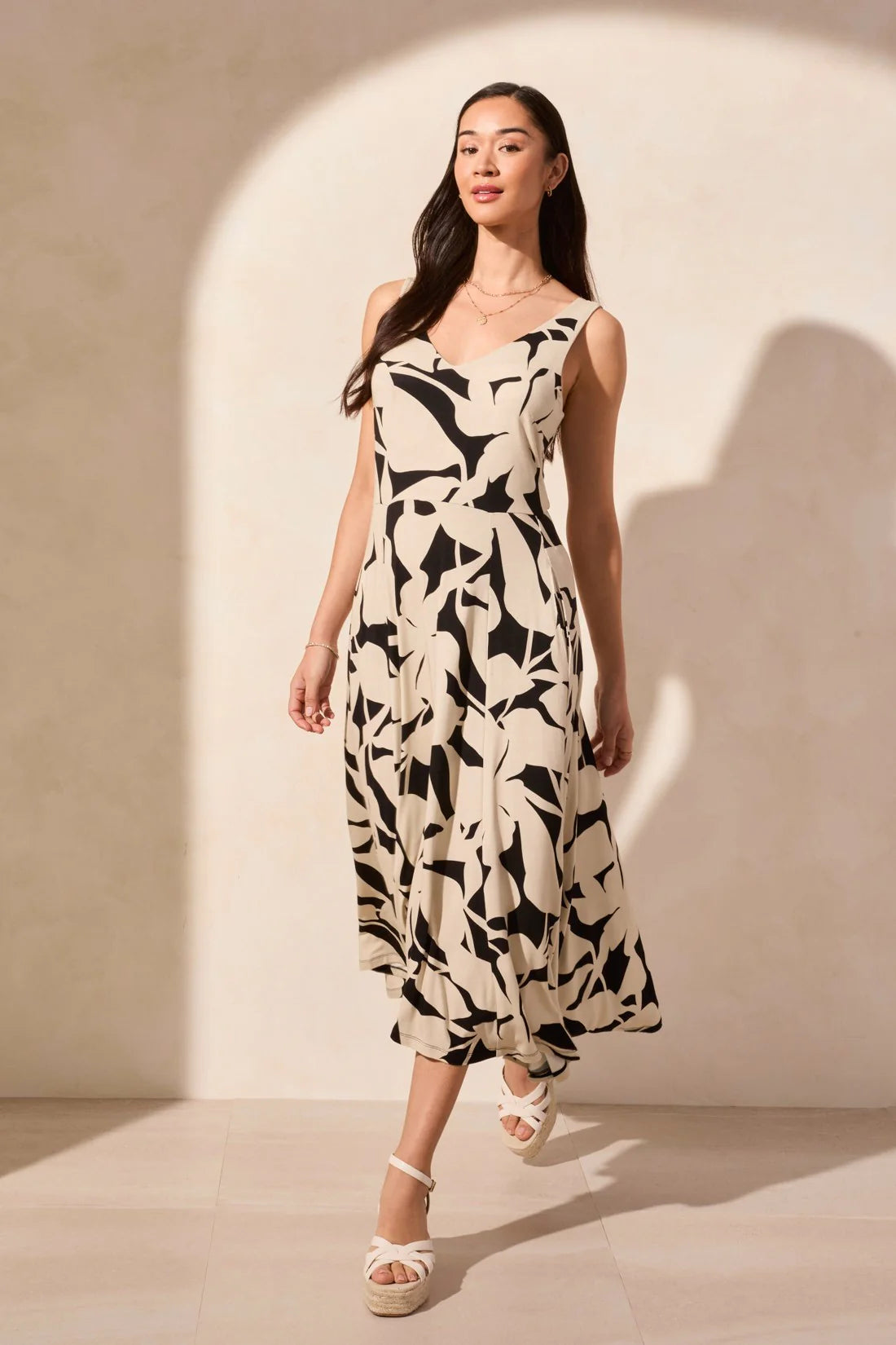 Turn heads in this sleeveless dress featuring a chic high-low hem and timeless flared silhouette. Crafted from flowy jersey fabric with an intricate print and a touch of stretch, it offers effortless style and all-day comfort.