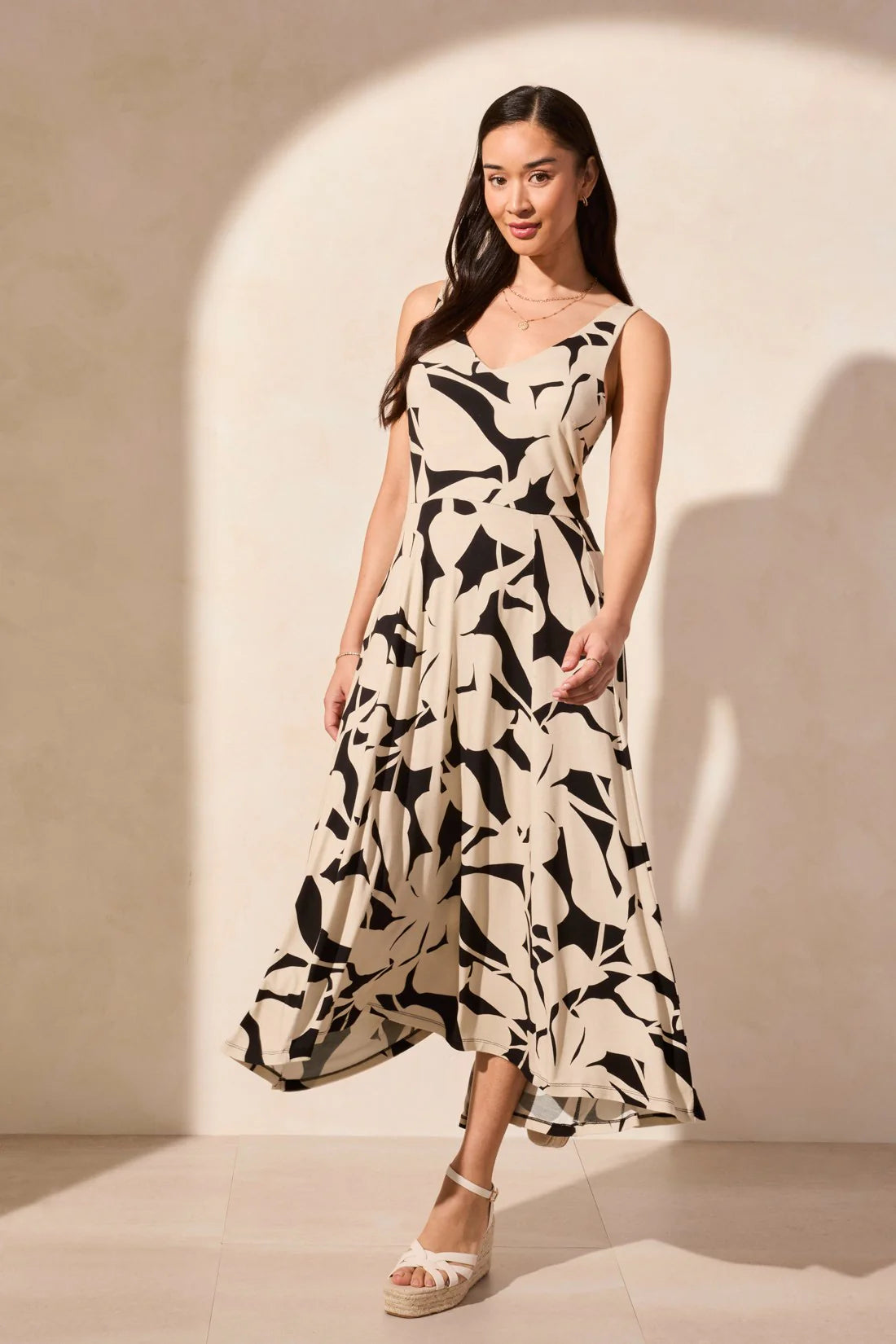 Turn heads in this sleeveless dress featuring a chic high-low hem and timeless flared silhouette. Crafted from flowy jersey fabric with an intricate print and a touch of stretch, it offers effortless style and all-day comfort.