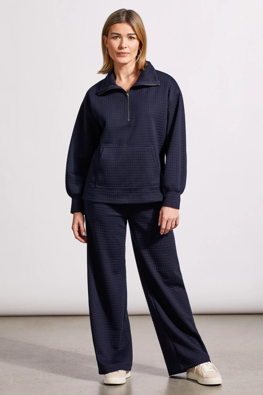 Crafted from knit fabric with a quilted finish, this long-sleeve funnel neck top spoils you with cozy comfort. It's styled with an adjustable half-zip at the neck, a roomy kangaroo pocket, and a high-low hem that's just as flattering as it is practical. Pair them with the matching pants to bring coordinated flair to casual days.