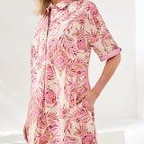 Woman wearing a pink and white patterned dress on a white background