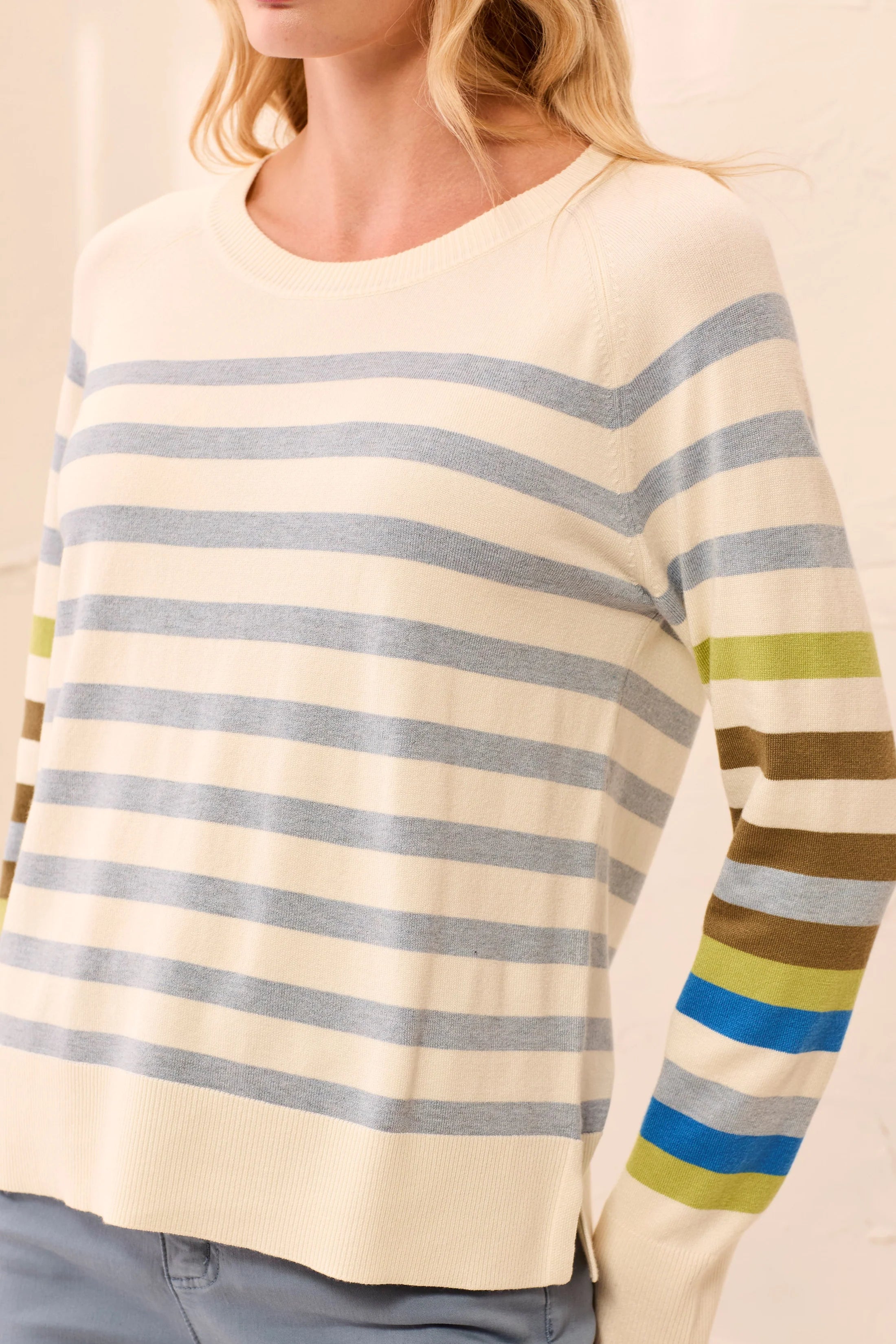 Close-up of a person wearing a striped sweater with a neutral background