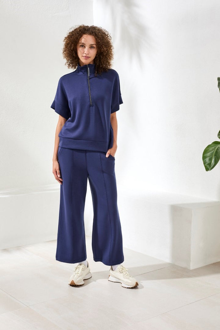 Woman wearing blue short sleeved track suit on white back ground