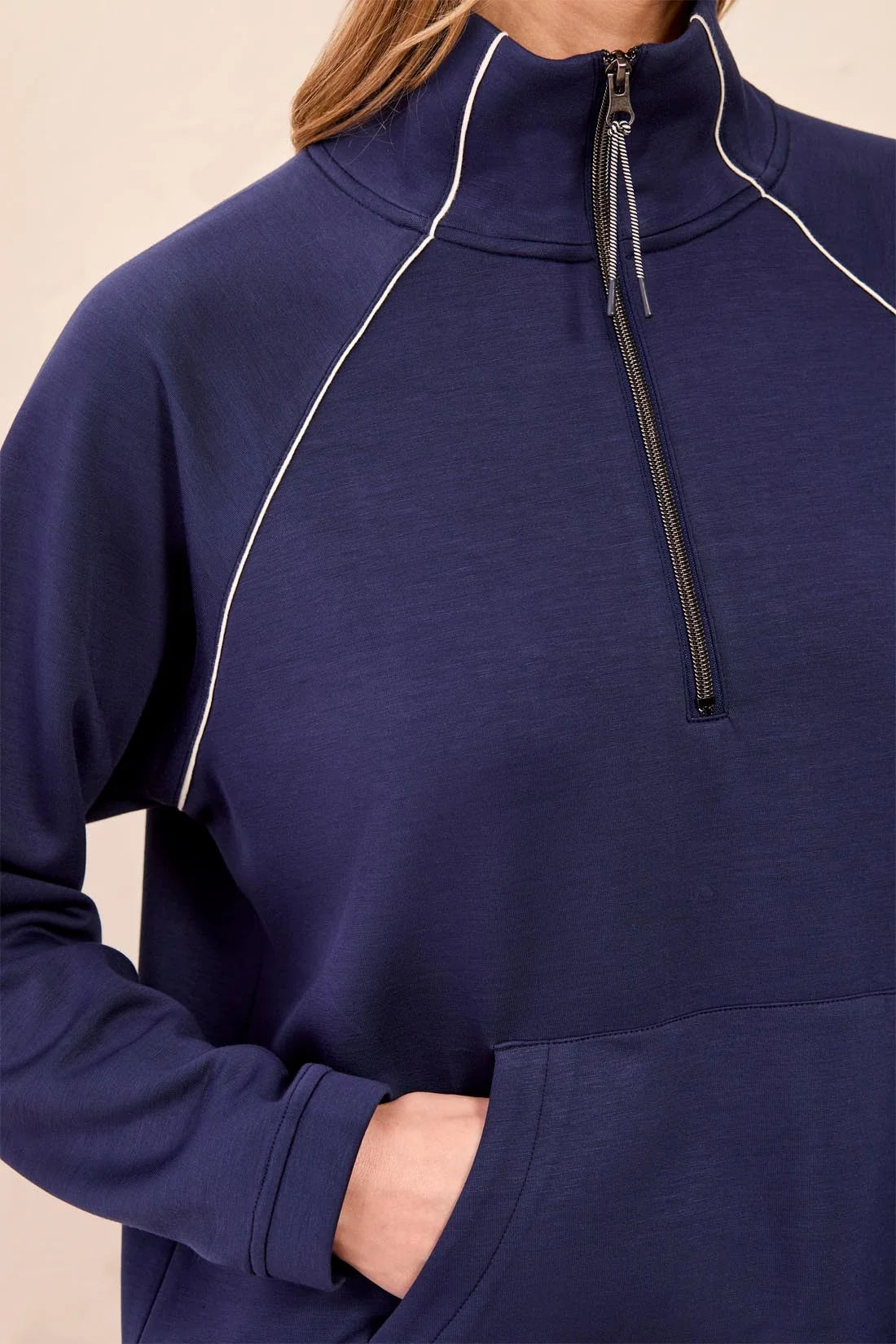 Navy blue pullover with a zipper on a beige background
