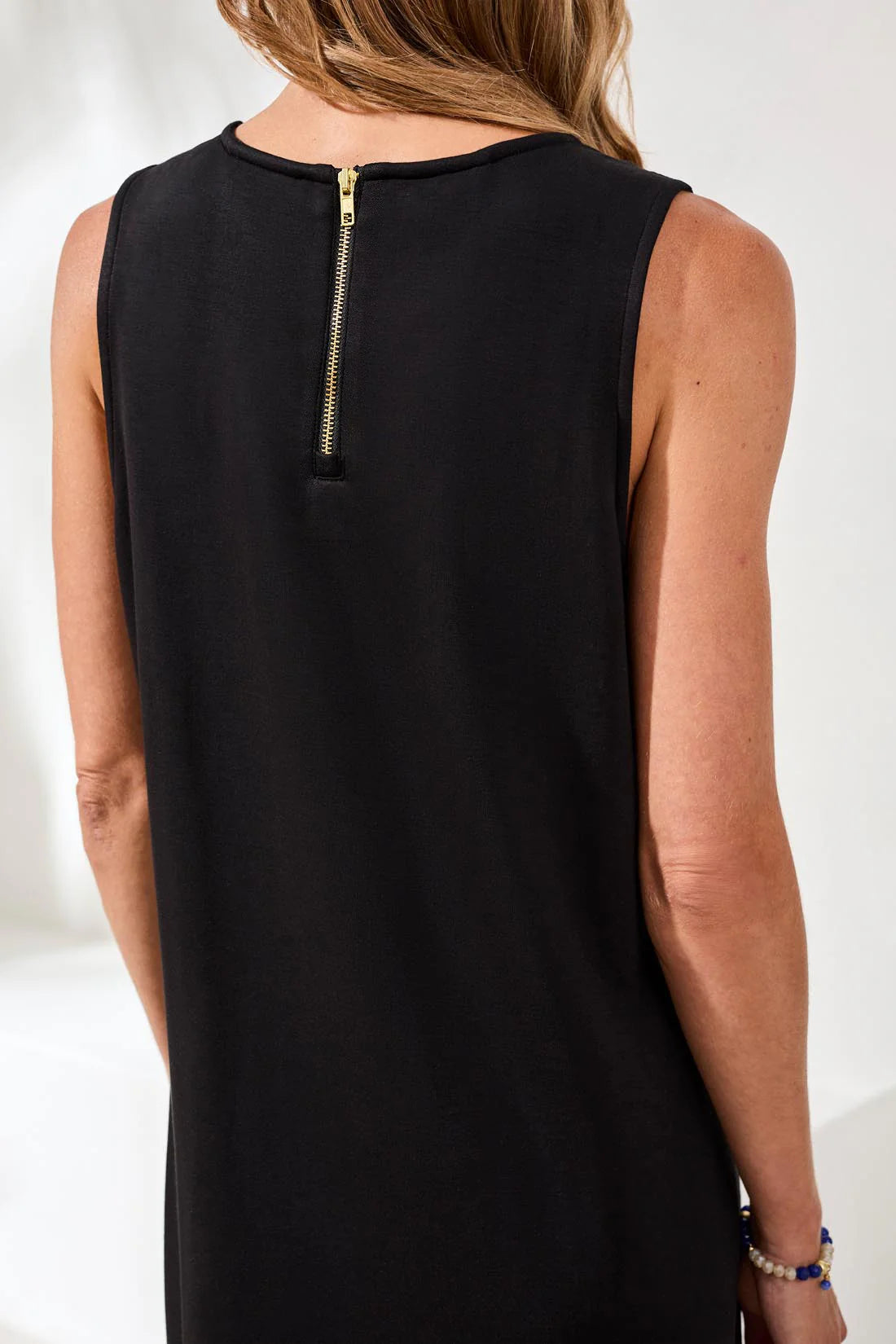 Black sleeveless dress with a zipper detail on a white background
