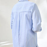 Person wearing a light blue shirt against a white background