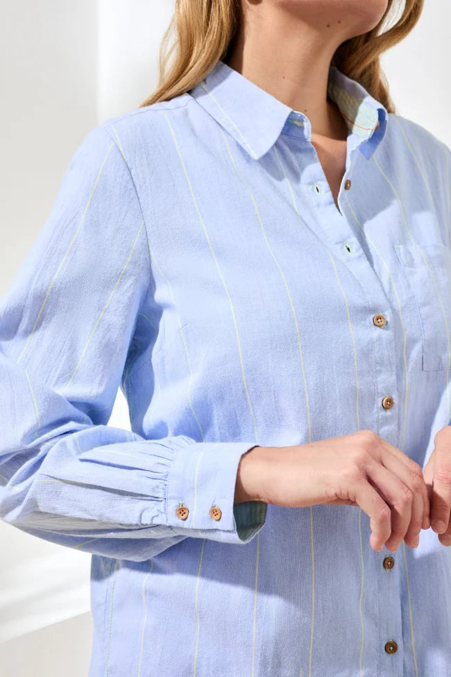 Light blue striped shirt with rolled-up sleeves worn by a person.