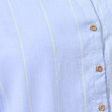 Light blue shirt with stripes and wooden buttons on a light blue background