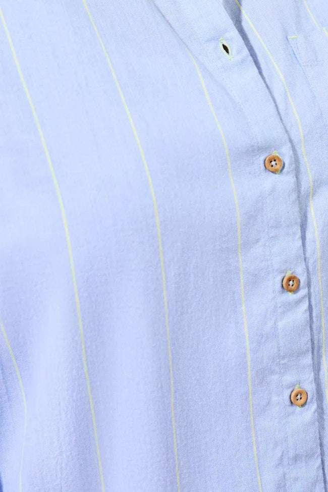 Light blue shirt with stripes and wooden buttons on a light blue background