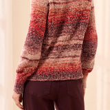 Person wearing a patterned sweater with a neutral background