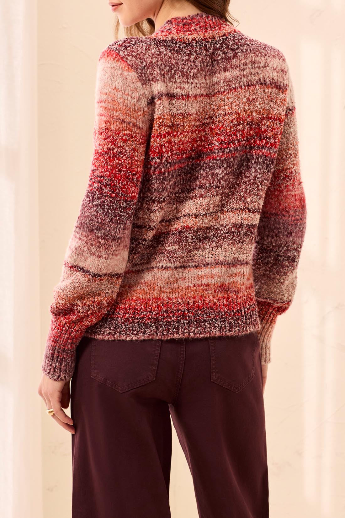 Person wearing a patterned sweater with a neutral background
