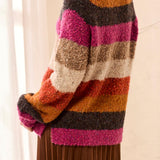 Colorful striped sweater worn by a person with a neutral background