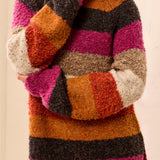 Multicolored striped sweater worn by a person on a beige background