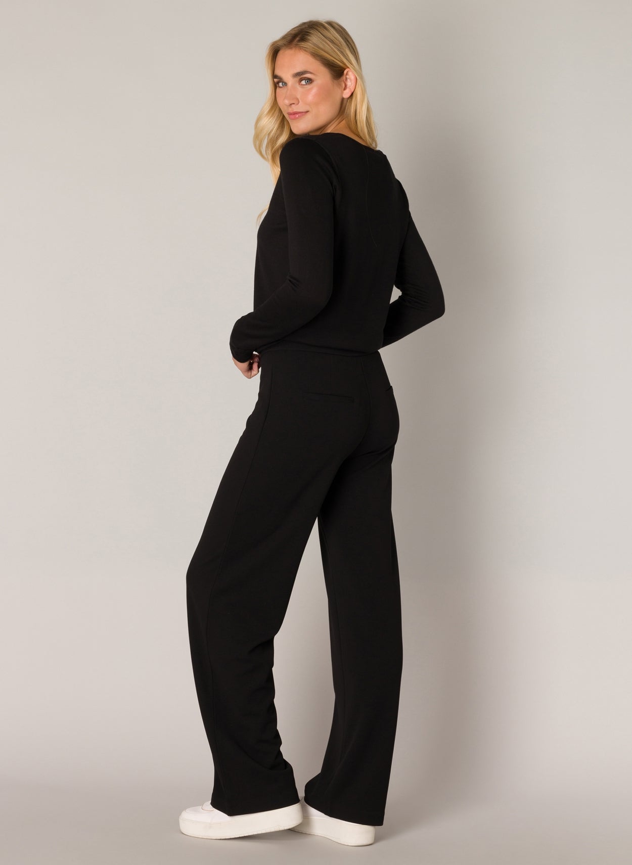 Yarah is a wide-leg trouser in recycled polyester with an elasticated waistband and closed welt pockets on the back panel. 