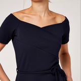 This dress features delicate frills, a romantic Bardot neckline, and a flattering fit.